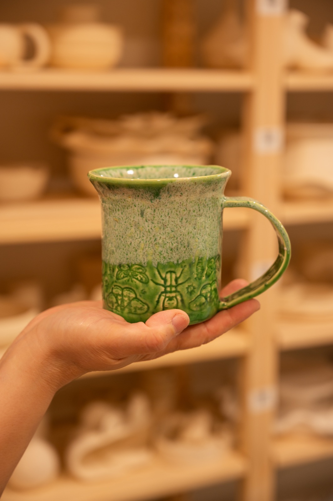 A hand-carved, glazed ceramic mug made at Lemarsis Pottery Studio