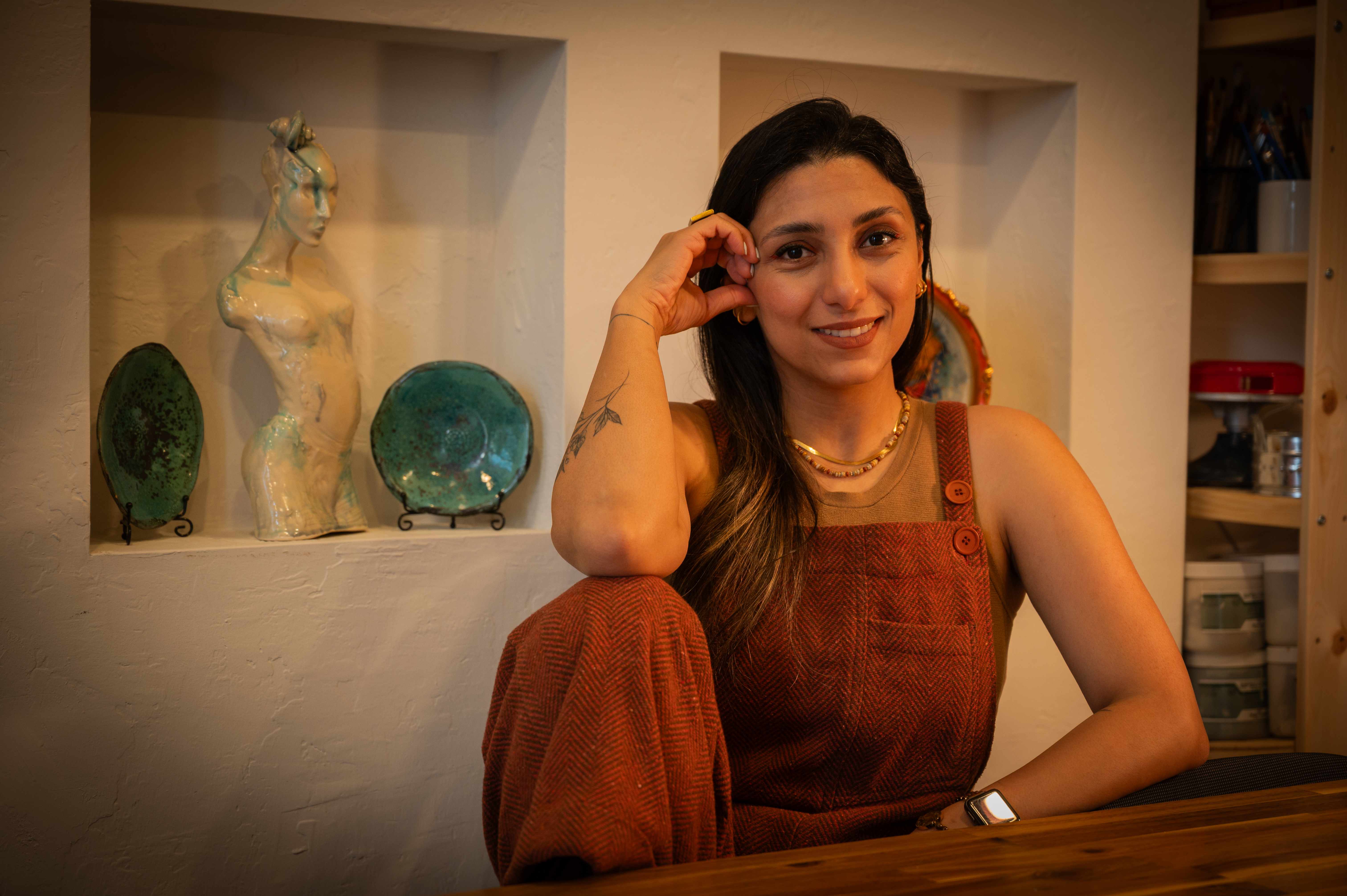 Nastaran Mortezavi in the pottery studio with ceramic displays