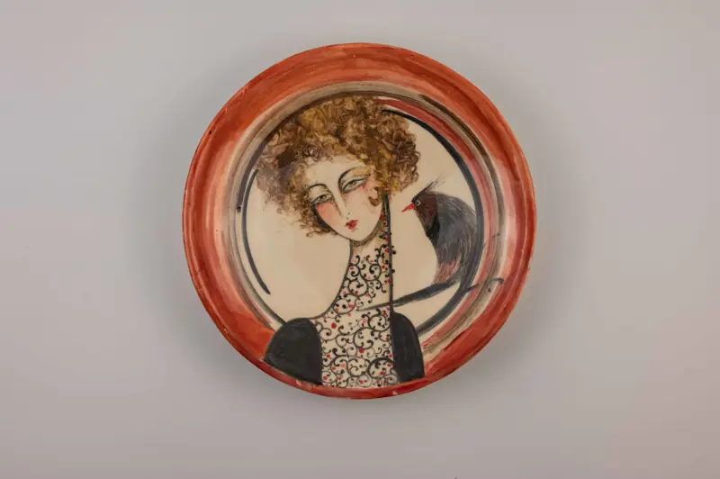 Ceramic plate by Marjan: a curly-haired portrait with a bird